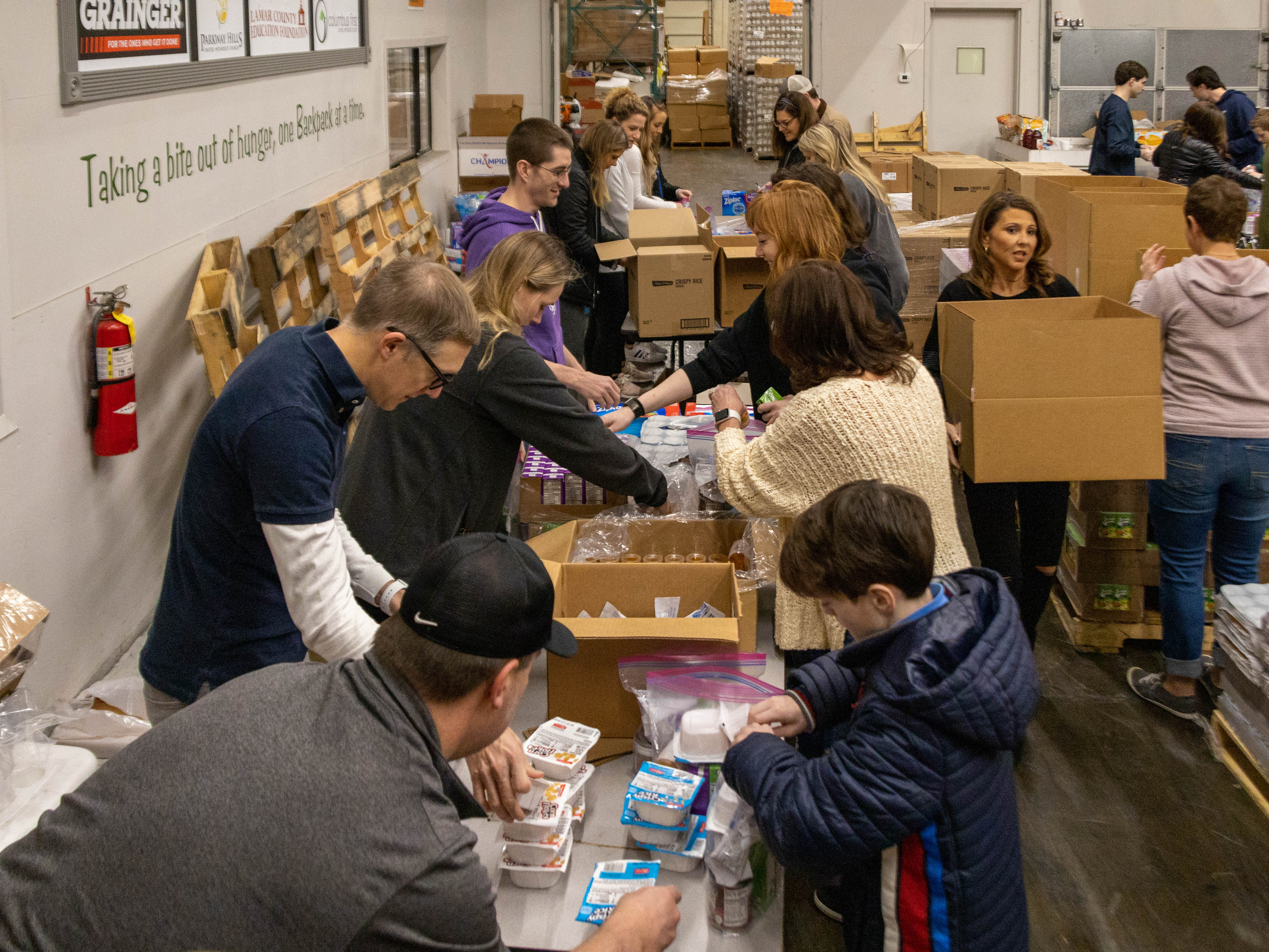 Volunteers pack meal kits for those in need